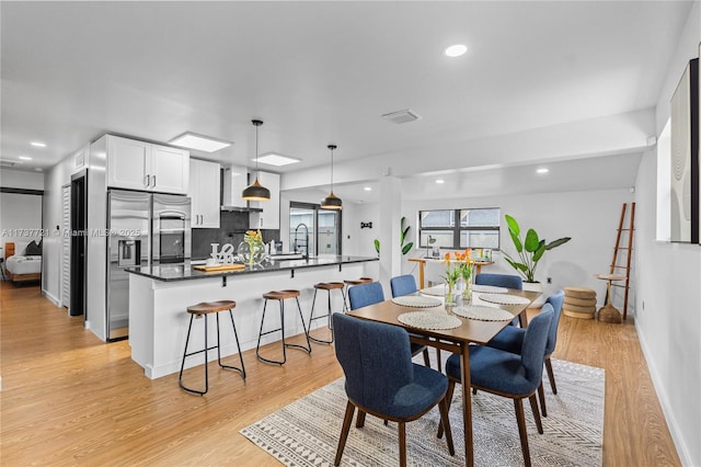 dining area featuring sink and light hardwood / wood-style floors