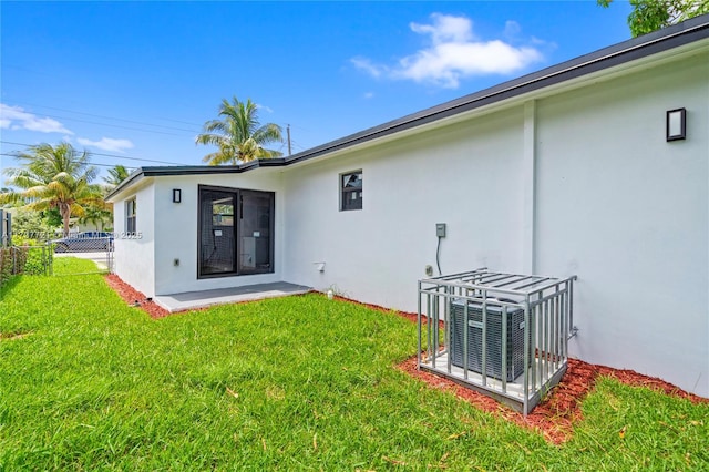 rear view of property with a yard and central AC