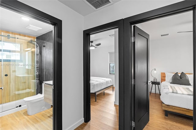 bathroom with hardwood / wood-style flooring, vanity, toilet, and walk in shower