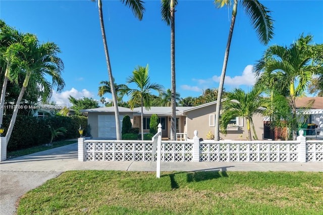 single story home featuring a garage and a front yard