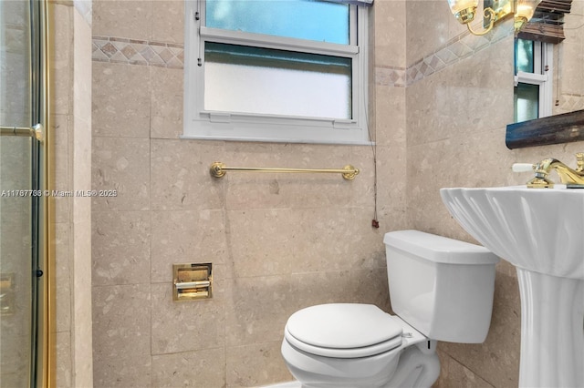 bathroom featuring tile walls, a shower with shower door, and toilet