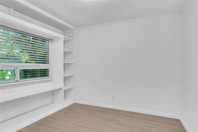 spare room with crown molding and light hardwood / wood-style flooring