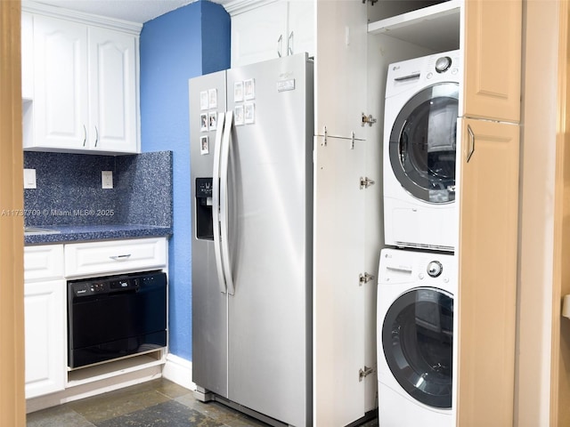 laundry area with laundry area, stacked washer and clothes dryer, and stone finish flooring