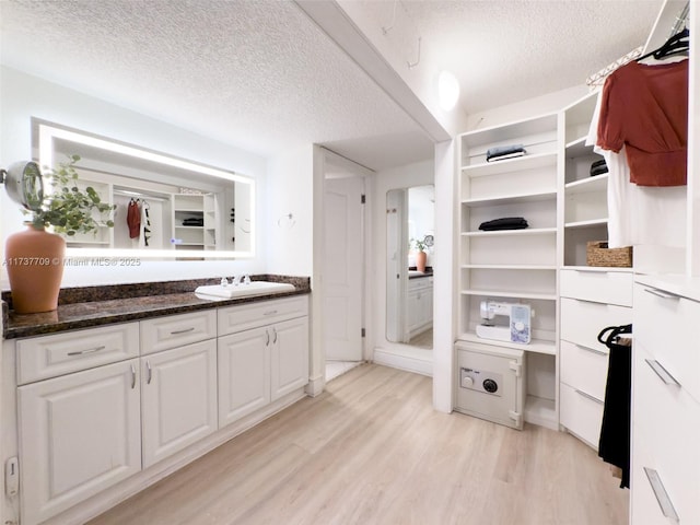 bathroom with a textured ceiling, wood finished floors, and vanity