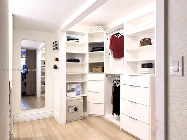 walk in closet with light wood-style flooring