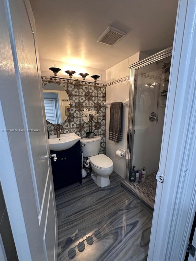 full bathroom with toilet, a shower stall, visible vents, and vanity