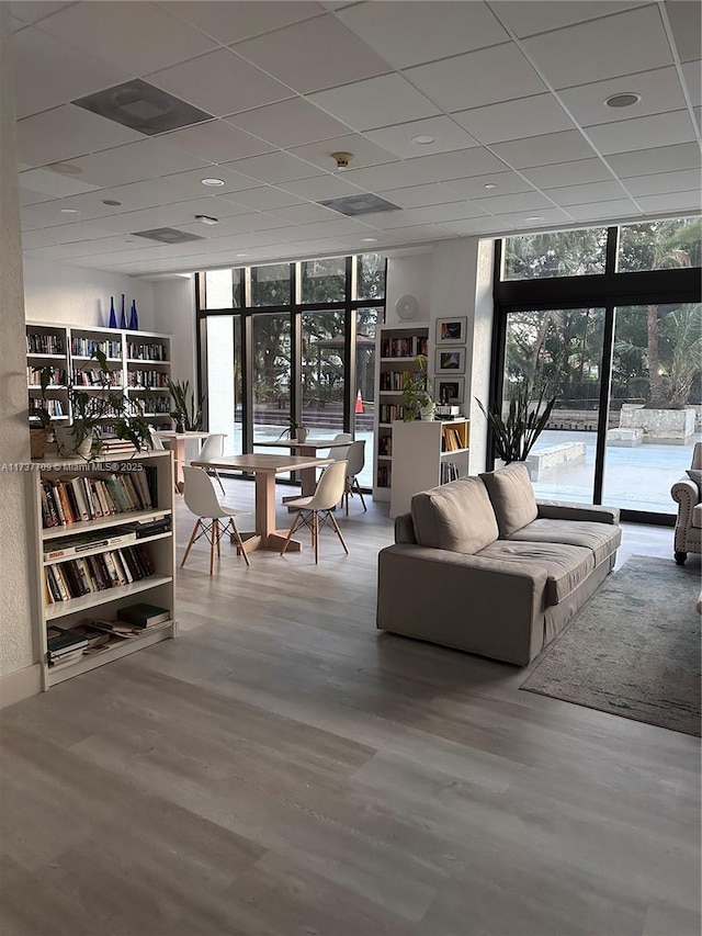 living room with a wealth of natural light, expansive windows, and wood finished floors