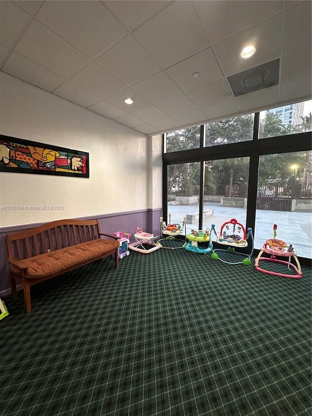 playroom featuring a wainscoted wall, a drop ceiling, carpet flooring, and recessed lighting