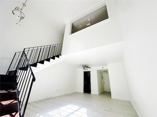 stairway with ceiling fan and hardwood / wood-style floors