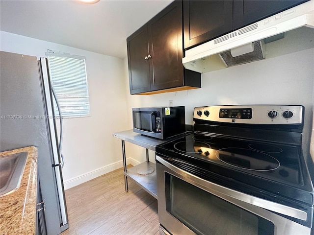 kitchen featuring dark brown cabinetry, stainless steel appliances, and light wood-type flooring