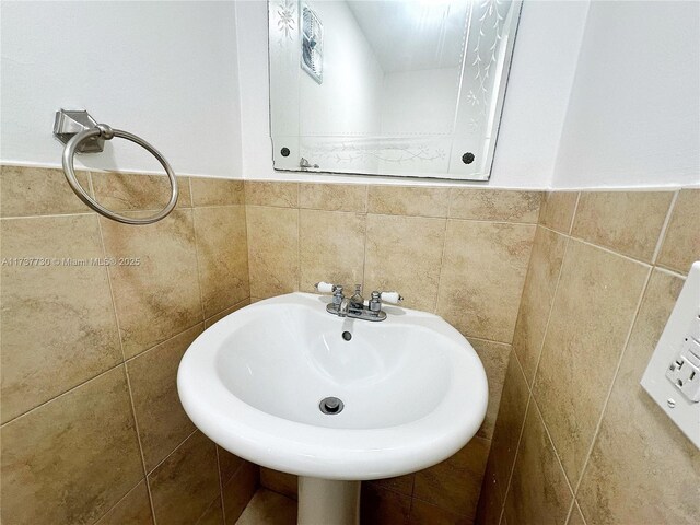 bathroom with tile walls and sink