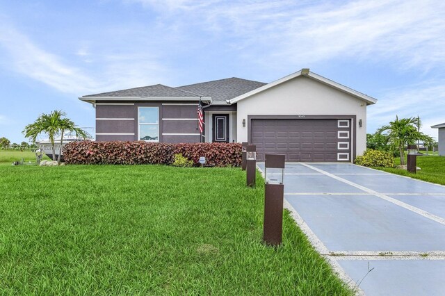 9049 Green Cir, La Belle, FL 33935 - view of front of home with driveway, roof with shingles, stucco siding, an attached garage, and a front lawn