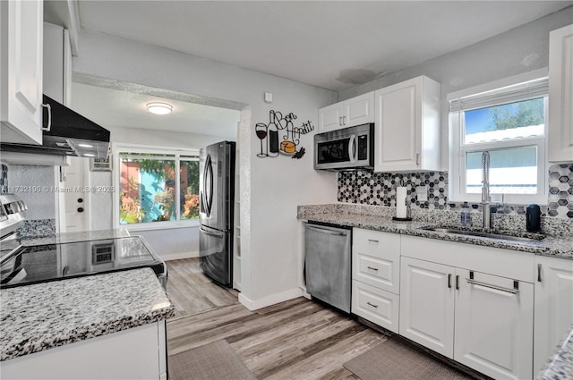 kitchen with sink, appliances with stainless steel finishes, light stone countertops, decorative backsplash, and white cabinets