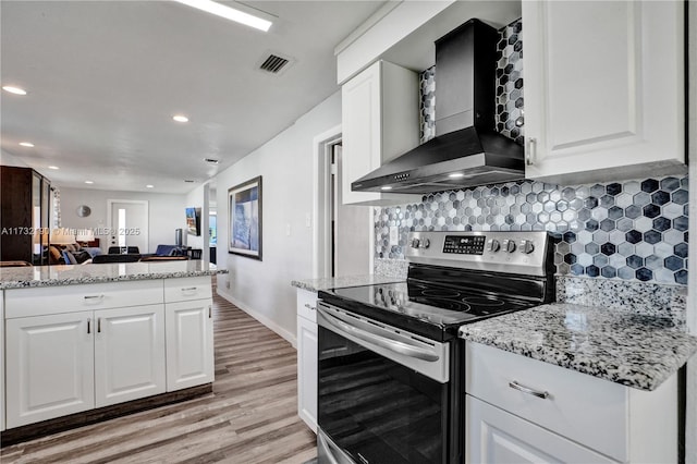 kitchen with white cabinetry, wall chimney range hood, and stainless steel electric stove