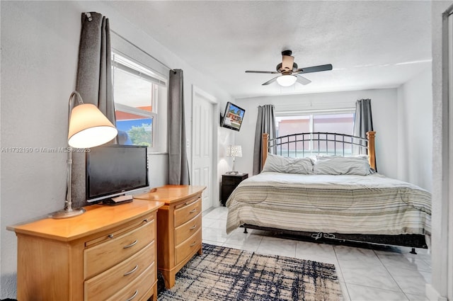 tiled bedroom featuring a textured ceiling and ceiling fan