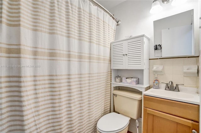 bathroom with vanity, toilet, and decorative backsplash