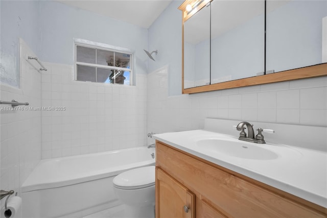 full bathroom featuring vanity, toilet, tiled shower / bath combo, and tile walls