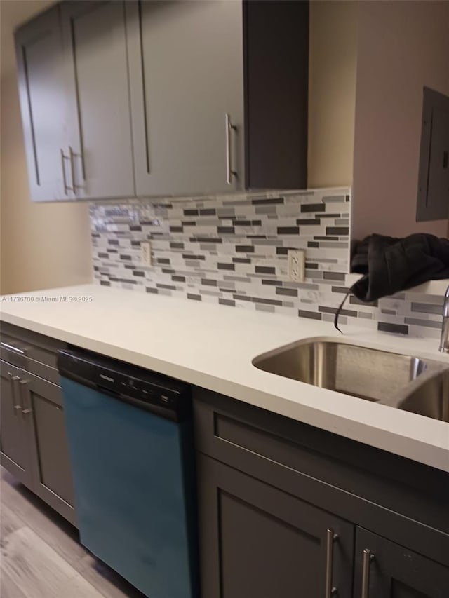 kitchen featuring electric panel, dishwasher, sink, and decorative backsplash