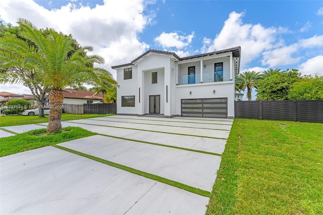 view of front of property featuring a garage, a front yard, and a balcony