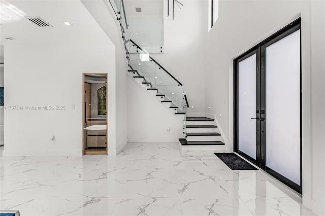 entrance foyer with a towering ceiling and french doors