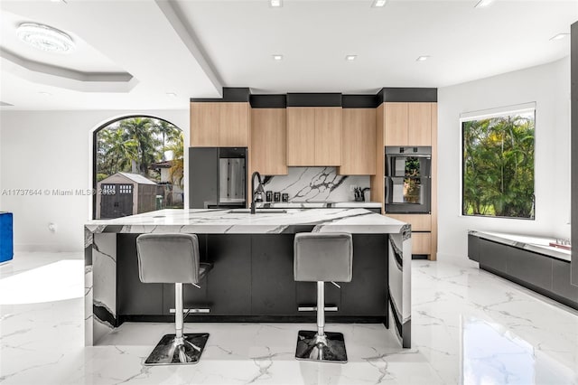 kitchen with a large island, sink, a kitchen breakfast bar, and black double oven