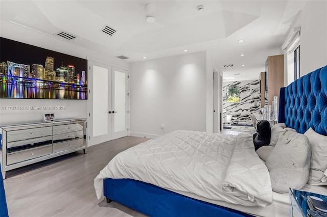 bedroom featuring french doors and hardwood / wood-style flooring