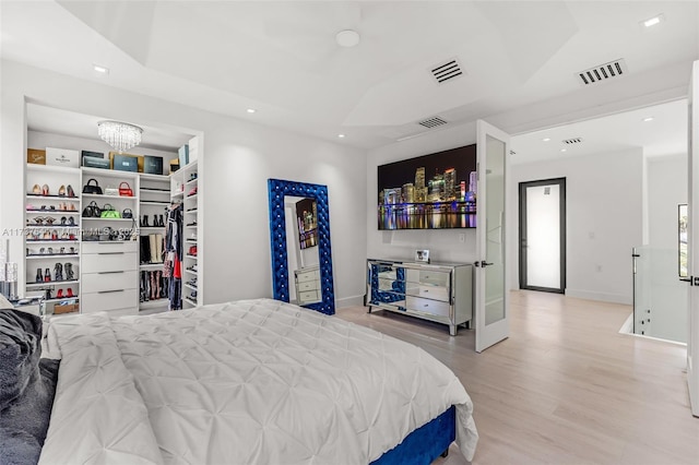 bedroom featuring a notable chandelier and light hardwood / wood-style flooring