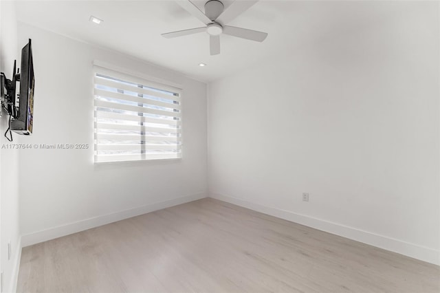 empty room with ceiling fan and light hardwood / wood-style flooring