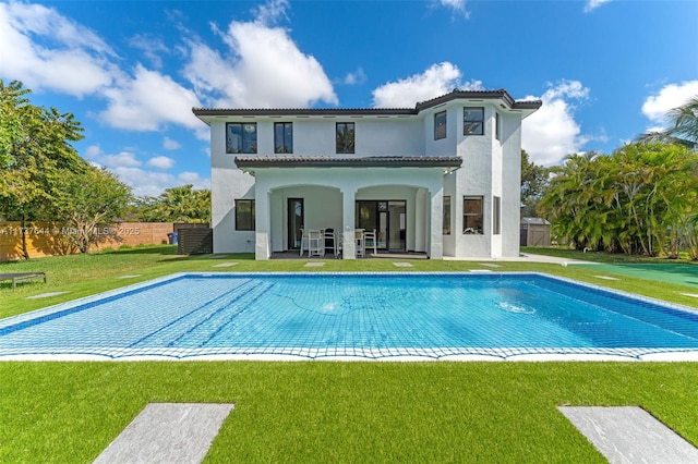 back of house featuring a patio area and a lawn