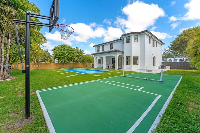 view of sport court featuring a lawn