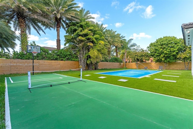 view of sport court featuring a fenced in pool, a yard, and tennis court