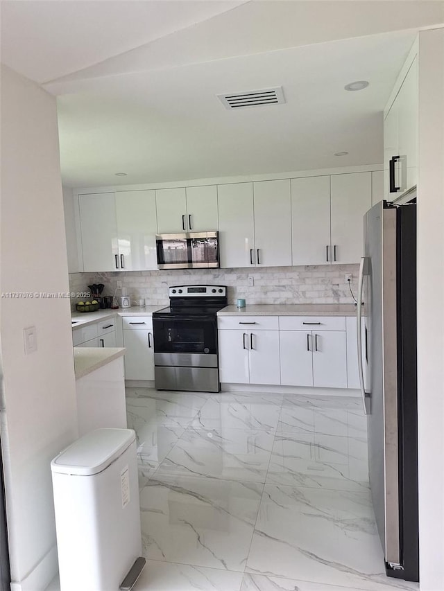 kitchen featuring white cabinetry, appliances with stainless steel finishes, and tasteful backsplash