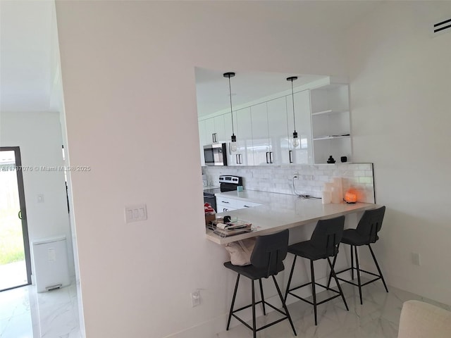 bar featuring tasteful backsplash, pendant lighting, white cabinets, and appliances with stainless steel finishes