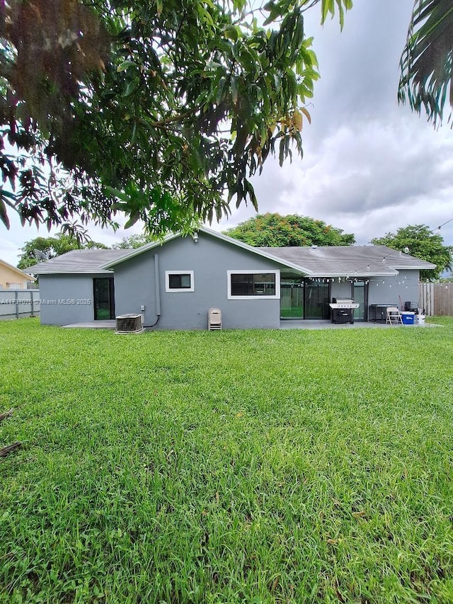 back of property featuring a yard and central AC unit