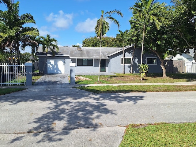 single story home featuring a garage and a front lawn