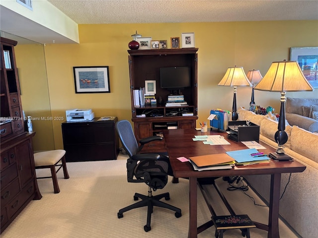 carpeted office space featuring a textured ceiling