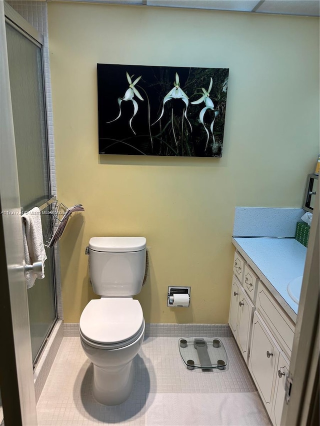 bathroom featuring tile patterned flooring, vanity, walk in shower, and toilet