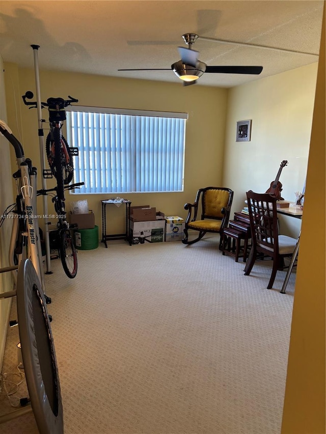 sitting room featuring ceiling fan and carpet