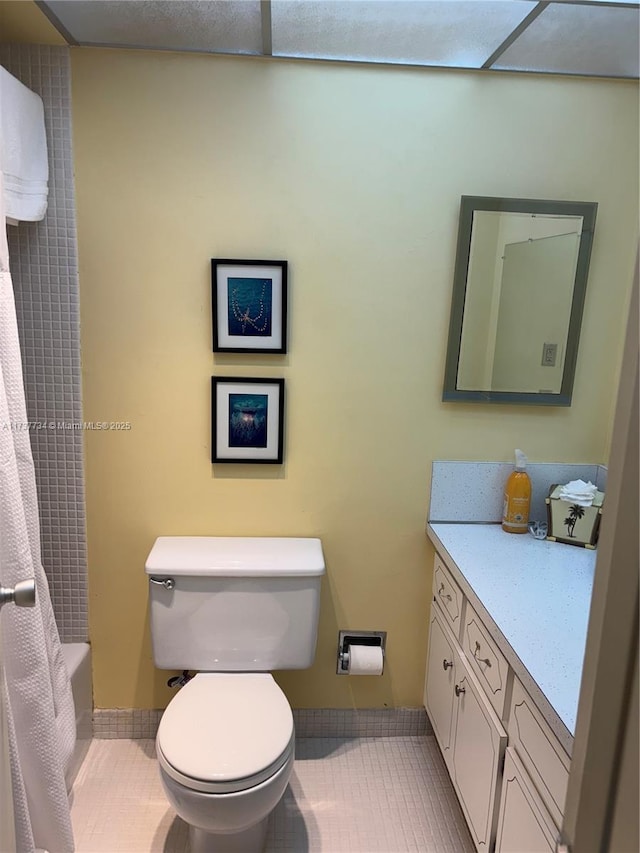 full bathroom featuring tile patterned floors, vanity, toilet, and shower / bath combo with shower curtain