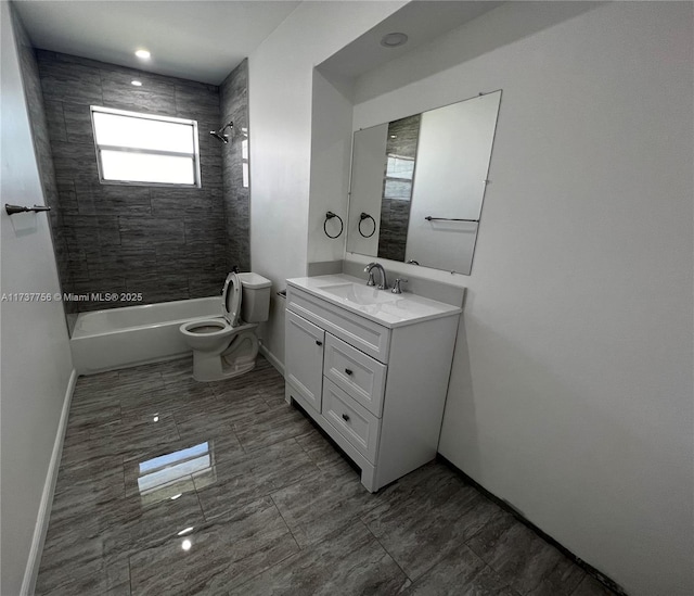 full bathroom with tiled shower / bath, vanity, and toilet