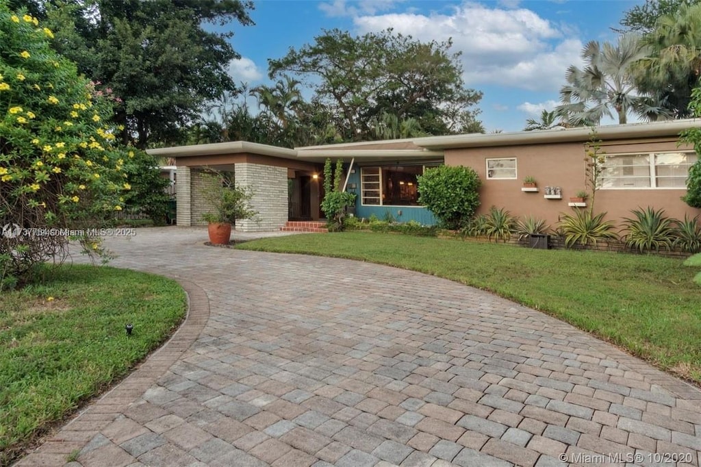 view of front of home with a front lawn and a carport