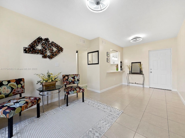 sitting room with light tile patterned flooring, visible vents, and baseboards