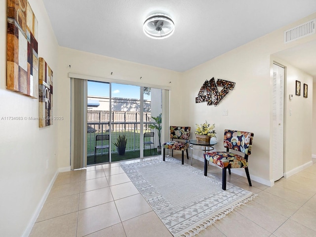 sitting room featuring light tile patterned floors, baseboards, and visible vents