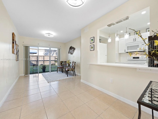 kitchen with range with electric cooktop, light tile patterned floors, kitchen peninsula, pendant lighting, and white cabinets