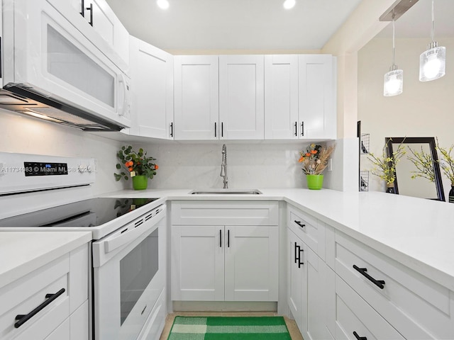 kitchen with white appliances, a sink, white cabinetry, light countertops, and decorative backsplash