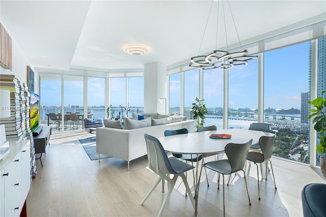 sunroom with a water view, plenty of natural light, and a notable chandelier