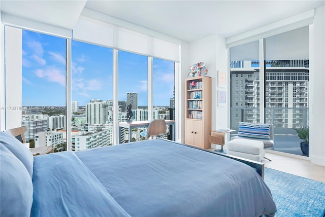 bedroom with hardwood / wood-style flooring and expansive windows