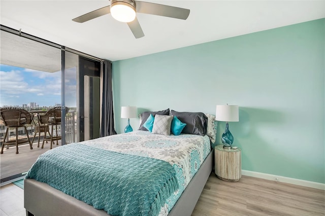 bedroom with expansive windows, access to exterior, ceiling fan, and light hardwood / wood-style flooring