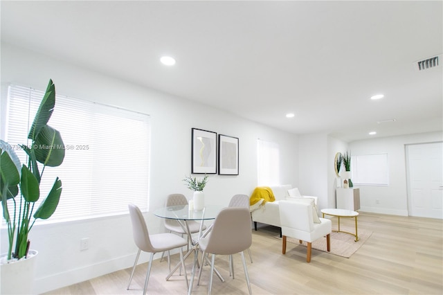 dining area with light hardwood / wood-style flooring and a healthy amount of sunlight