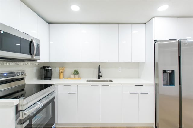 kitchen with white cabinetry, appliances with stainless steel finishes, sink, and tasteful backsplash